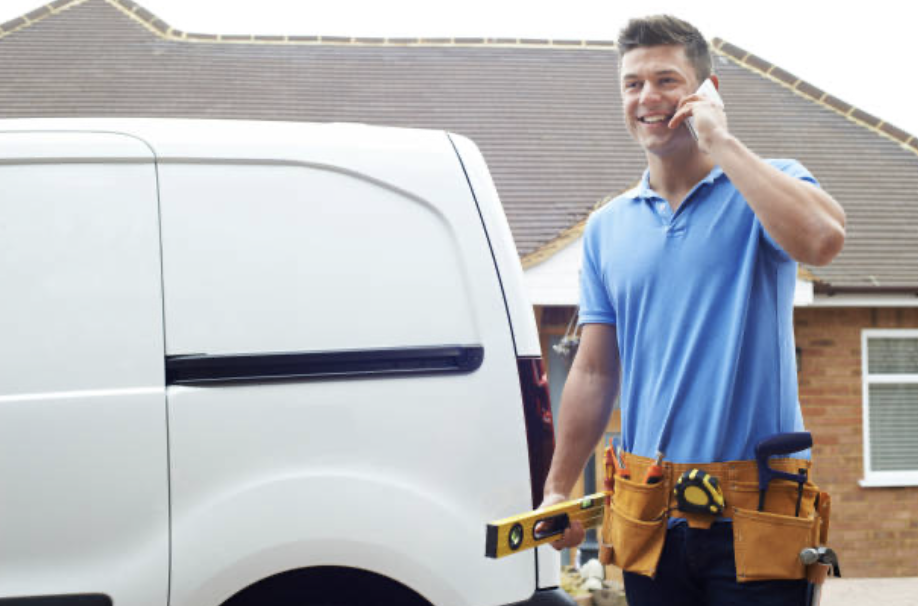Contractor smiling on phone near work van